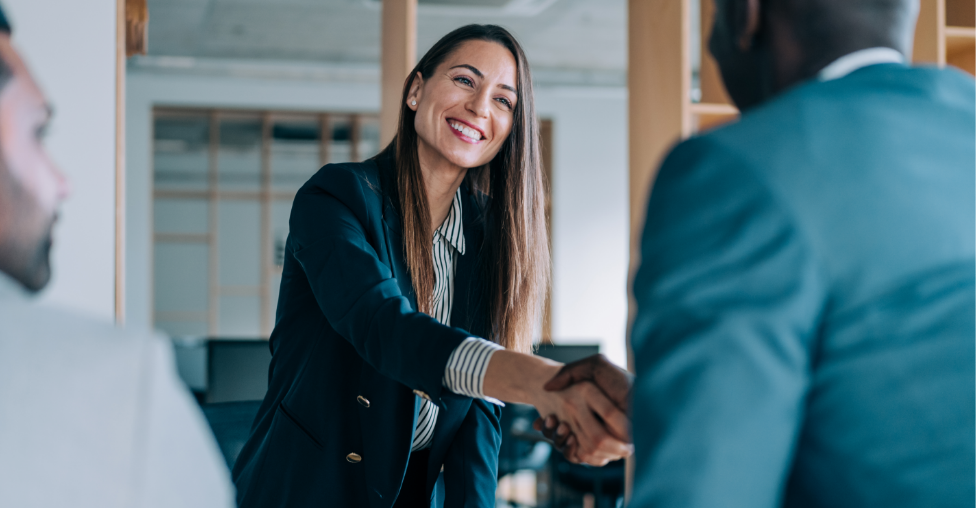 Businessfrau schüttelt Mann im Anzug die Hand