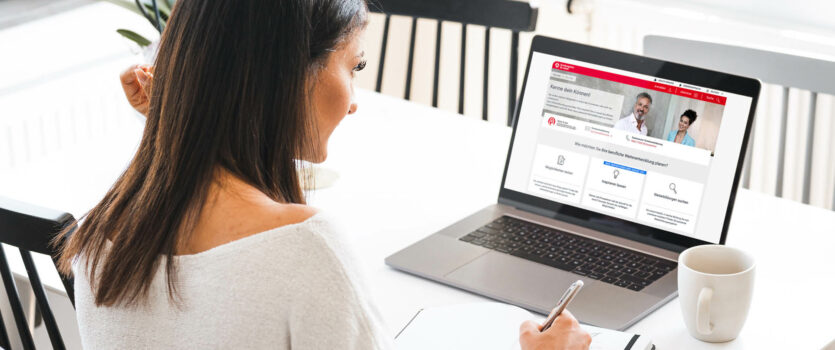 Junge Frau arbeitet von Zuhause an ihrem Computer