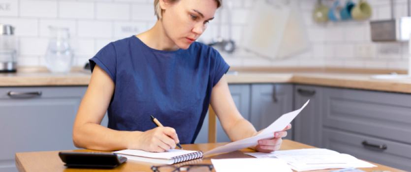 frau-rechnet-und-schreibt-am-tisch