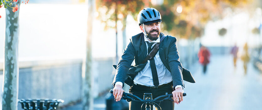 Geschäftsmann fährt Fahrrad mit einem Helm
