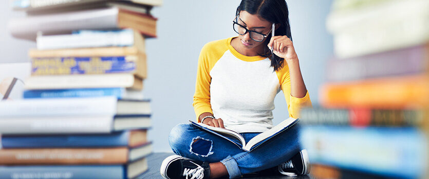 Frau mit Brille liest in einem Buch