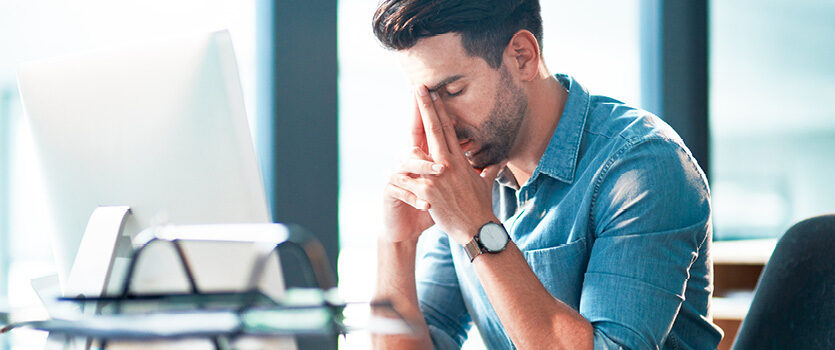 Deprimierter Mann sitzt vor einem Computer