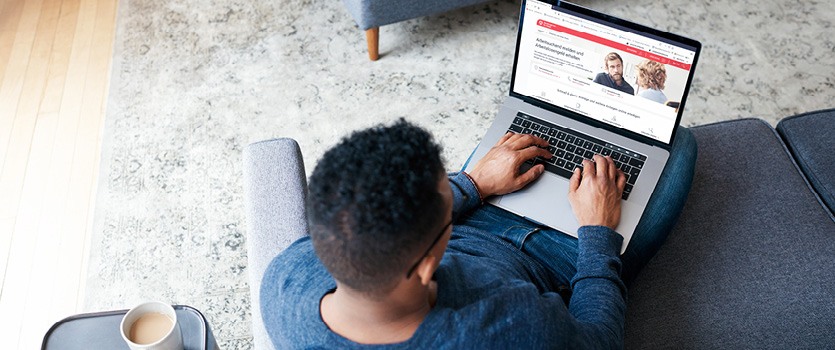 Ein junger Mann recherchiert im Internet wie er sich arbeitsuchend melden kann